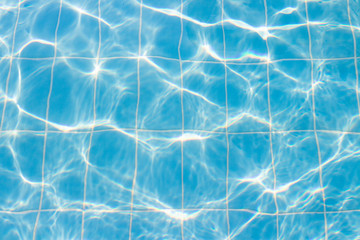 Water vibrations in the swimming pool with sun reflection. blue swimming pool surface, water background in swimming pool. Flat lay, top view