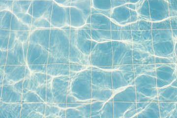 Water vibrations in the swimming pool with sun reflection. blue swimming pool surface, water background in swimming pool. Flat lay, top view