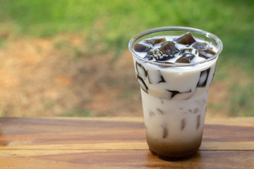 Grass jelly with fresh milk and caramel in plastic cup