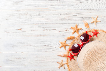 Beach hat with seashells on brown wooden table. summer background concept with copy space top view