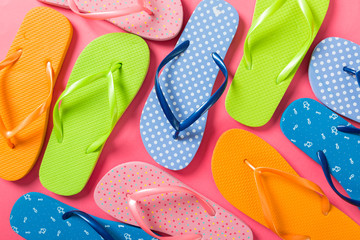 a lot of flip flop colored sandals, summer vacation on colored background, copy space top view - obrazy, fototapety, plakaty