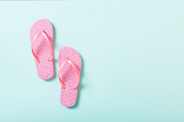 pink flip flops on blue background. Top view with copy space