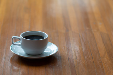 Close up a cup of hot  coffee on wooden table