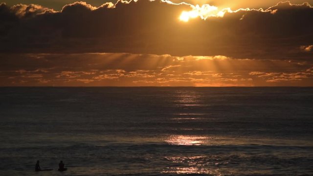 Surfers behold a beautiful cloudy sunrise on the Gold Coast, Australia