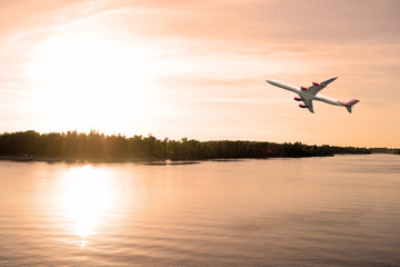 Airliner over the river. The evening sunset.