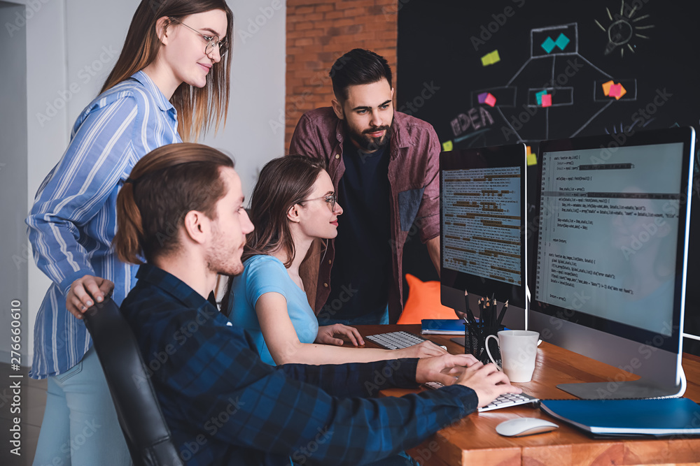 Poster team of programmers working in office