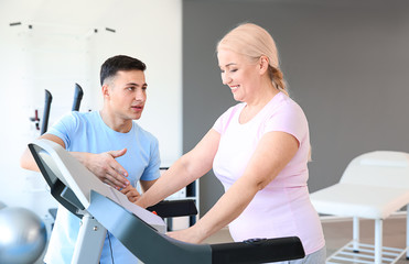 Obraz premium Physiotherapist working with mature patient in rehabilitation center