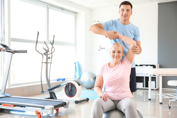 Physiotherapist working with mature patient in rehabilitation center