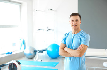 Young male physiotherapist in rehabilitation center - obrazy, fototapety, plakaty