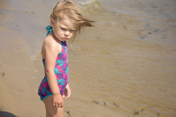 Sad and angry little girl on beach 