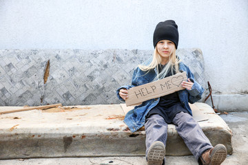 Homeless little girl begging for help outdoors