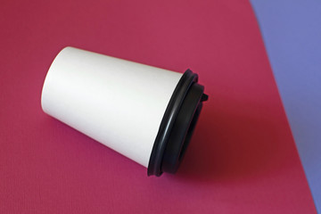 Mockup of coffee paper cup on a magenta and lilac background.