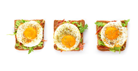 Tasty toasts with bacon and fried egg on white background
