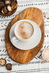 Mushroom latte with shiitake powder and vegetarian blend milk on a wooden tray on a table. Healthy useful vegan drink.
