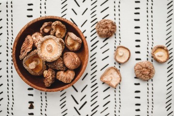 Fototapeta na wymiar Chinese dried mushrooms Shiitake in a wooden bowl on a table. The concept of medicinal superfoods for health. Top view, flat lay.