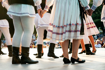 Traditional romanian dancers in traditional costumes hand in hand on stage