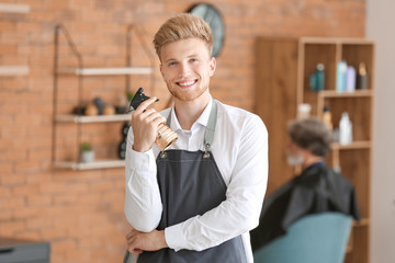 Young male hairdresser in beauty salon