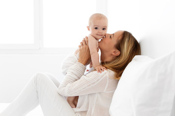 Mother holding and kissing her baby