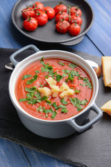 Pot of tasty tomato cream soup on wooden table