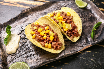 Plate with tasty fresh tacos on wooden background