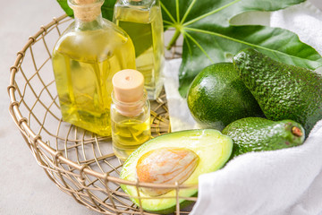 Fresh ripe avocados and essential oil in basket