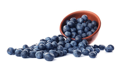 Bowl and scattered blueberry on white background