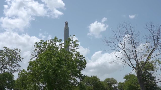View of San Jacinto Monument through trees in Houston, Texas