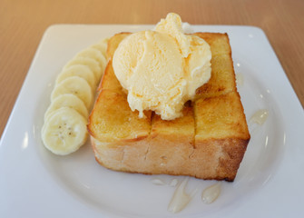 Dessert bread honey santos vanilla ice cream with banana fruit on white plate in the cafe coffee shop