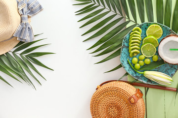 Summer composition with beach accessories, fruits and tropical leaves on white background