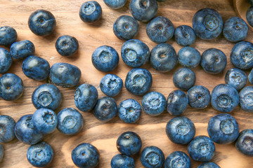 Many ripe blueberry on wooden background