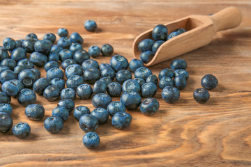 Scoop with ripe blueberry on wooden background