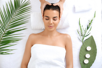 Beautiful young woman receiving massage in spa salon