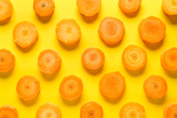Many slices of carrot on color background