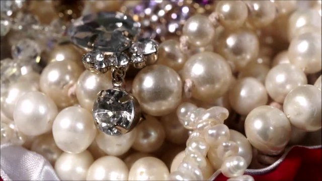 Rotating imitation jeweleries in a red velvet box.