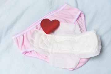 Sanitary napkin or feminine sanitary pad on panties with red heart - Female hygiene means women Period Product absorbent sheets