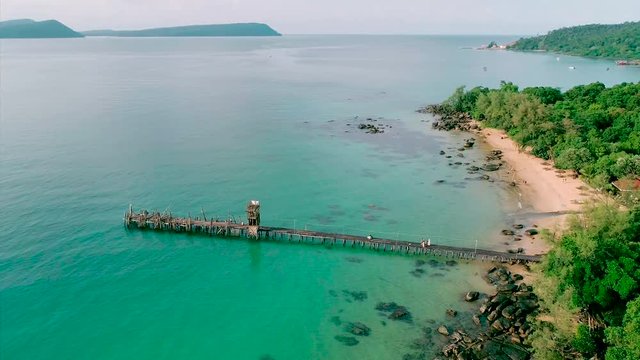Aerial view of long pier with wild beach, white sand. Forest on background. Top view from drone, adventure view. Royalty high quality free stock footage. Koh Rong Island, Cambodia.