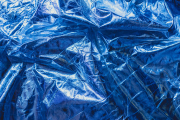 The texture of the crumpled fabric is metallic blue color. Place for your text.