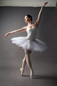 Young beautiful ballerina is posing in studio