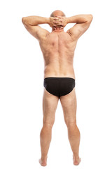 Adult fat man in black shorts, full-length, rear view. Isolated on a white background. Vertical.