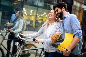 Smiling young couple going for a bike ride on a sunny day in the city