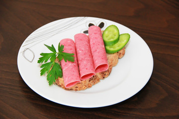 sandwich of rye bread with meat sausage, cucumbers and parsley