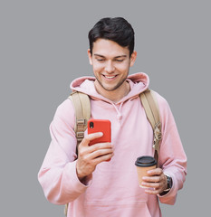Young  handsome man with smart phone. Smiling student men going on a travel. Isolated on gray background