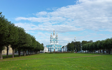 Fototapeta na wymiar Saint Petersburg in the summer. View from the city park with green lawns on the Smolny Cathedral on a sunny day. Beautiful cityscape