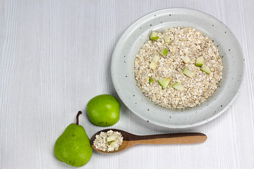 dish with oatmeal and pieces of apple and pear, Nutritious breakfast food healthy oatmeals