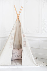 Cozy bright interior of the children's room with a wigwam. © stock28studio
