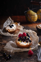 Baked pear with honey, cottage cheese, raspberries and currants. Fresh homemade dessert. Food composition in a low key. Close-up, copy space.
