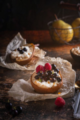 Baked pear with honey, cottage cheese, raspberries and currants. Fresh homemade dessert. Food composition in a low key. Close-up, copy space.