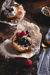 Baked pear with honey, cottage cheese, raspberries and currants. Fresh homemade dessert. Food composition in a low key. Close-up, copy space.