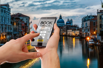 holding a smartphone with booking hotel room app on screen for make reservation