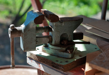 Old metal vice with cobwebs and rust outdoors on a sunny day